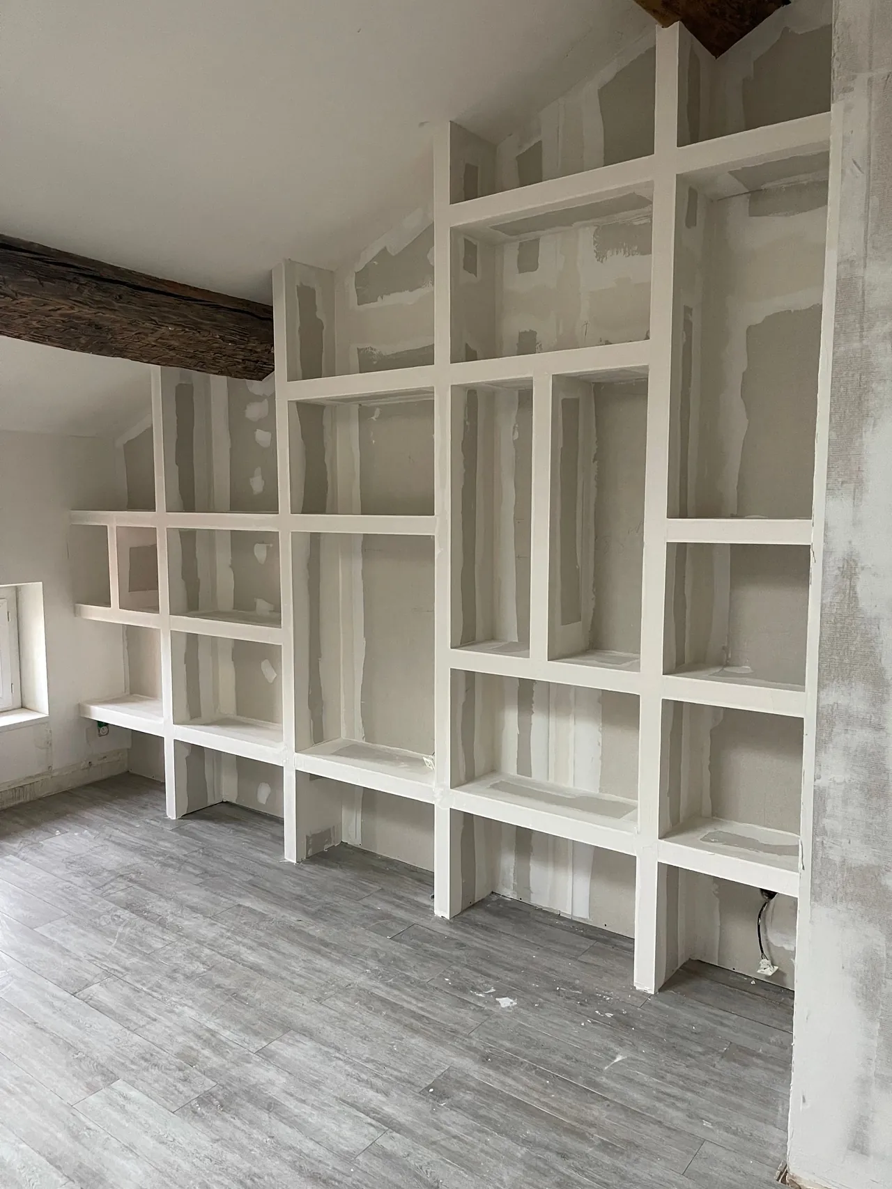 Bibliothèque murale sur mesure en plaques de plâtre, étagères et niches aux joints enduits