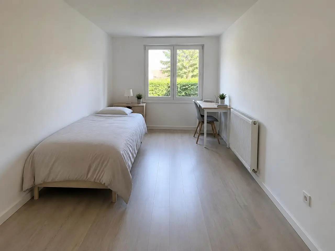 Chambre longue et simple aux murs et au plafond blancs, lit, petit bureau et radiateur près de la fenêtre