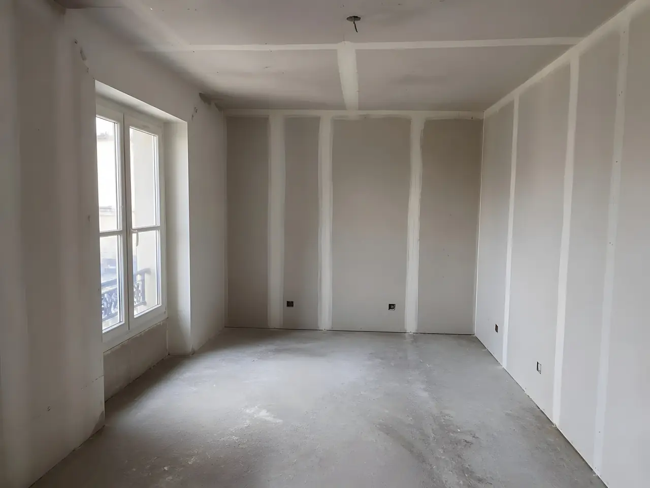 Pièce neuve aux murs et au plafond en plaques, bandes des joints enduites, boîtiers électriques en attente