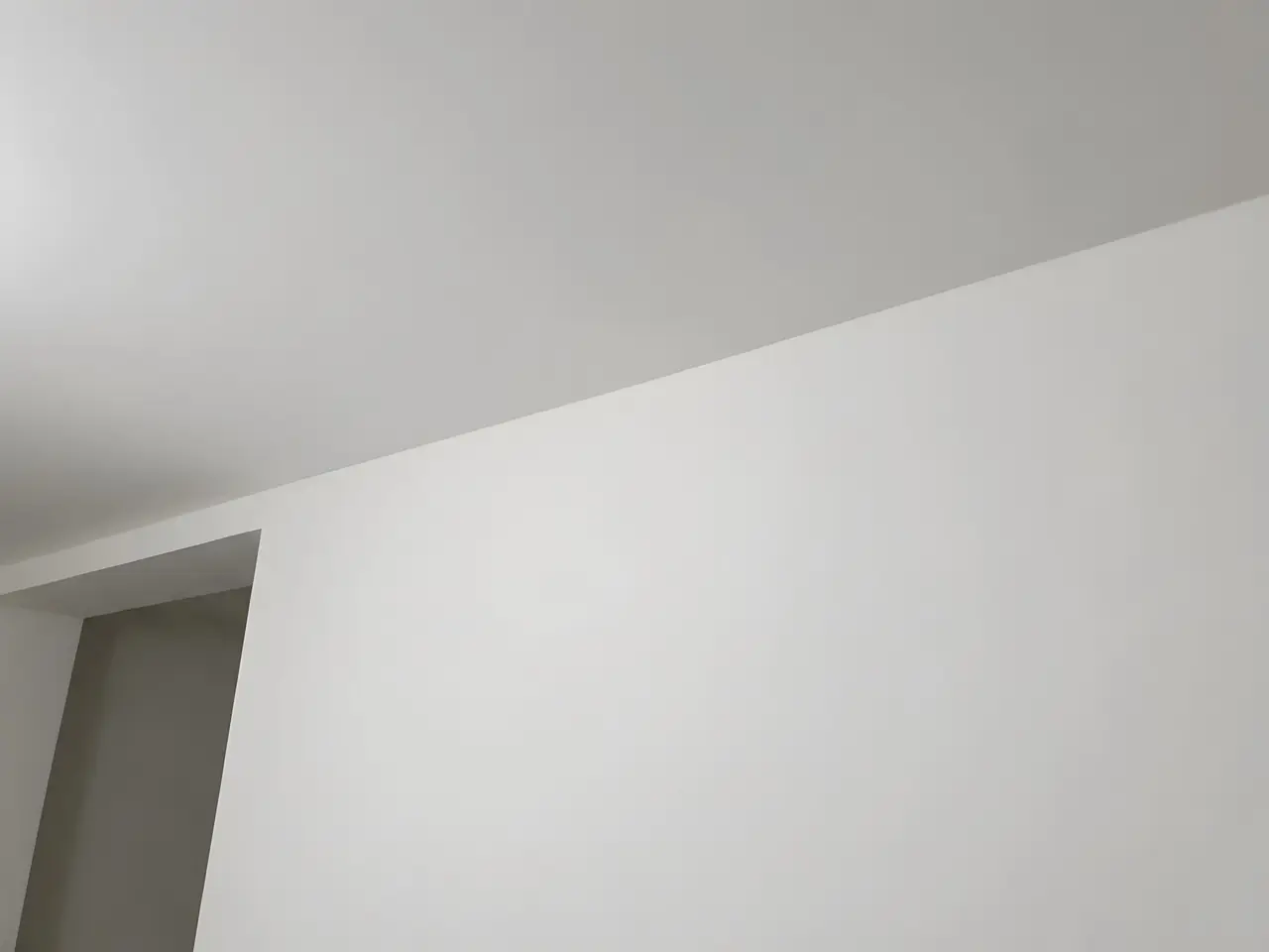Le même angle enduit et poncé : mur et plafond lisses, plus aucun joint ne se devine