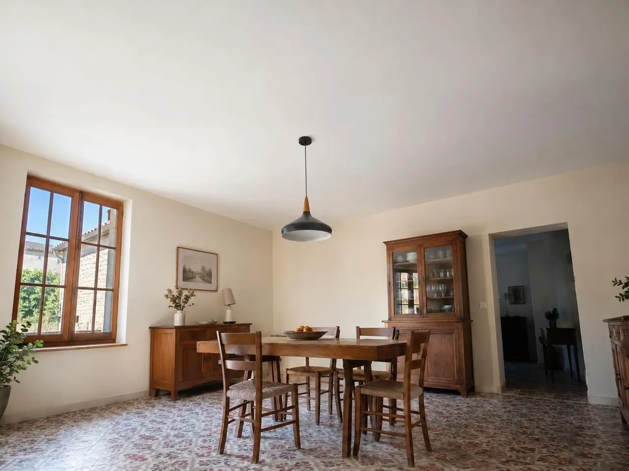 Salle à manger sous un plafond neuf blanc mat parfaitement plat, suspension noire au-dessus de la table en bois